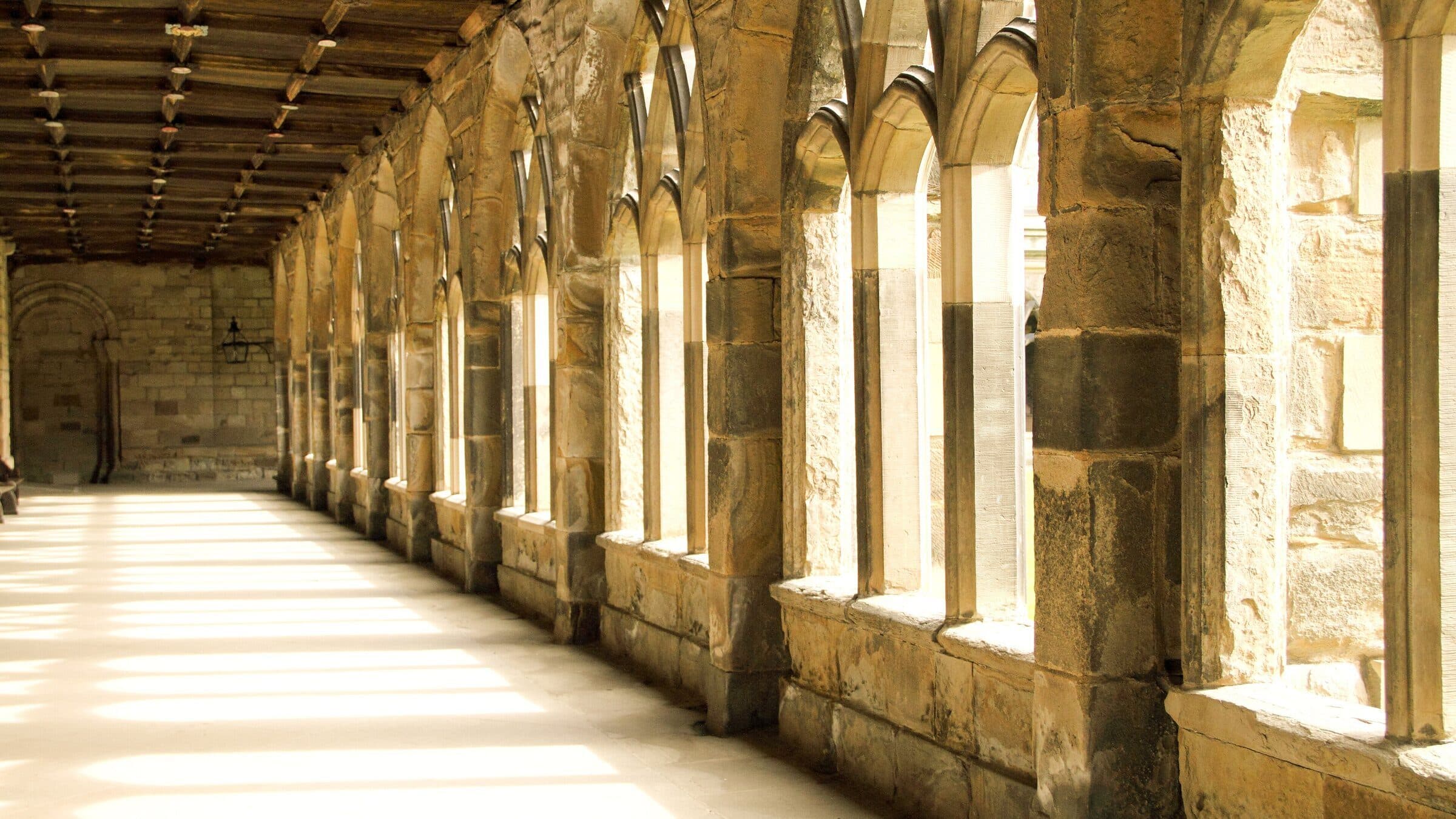 Sunlit cloister corridor at Durham Cathedral