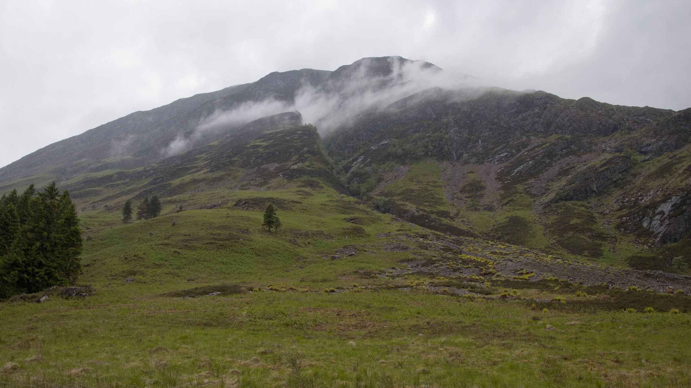 Clachaig Gully and its grassy hillside beneath the misty mountains